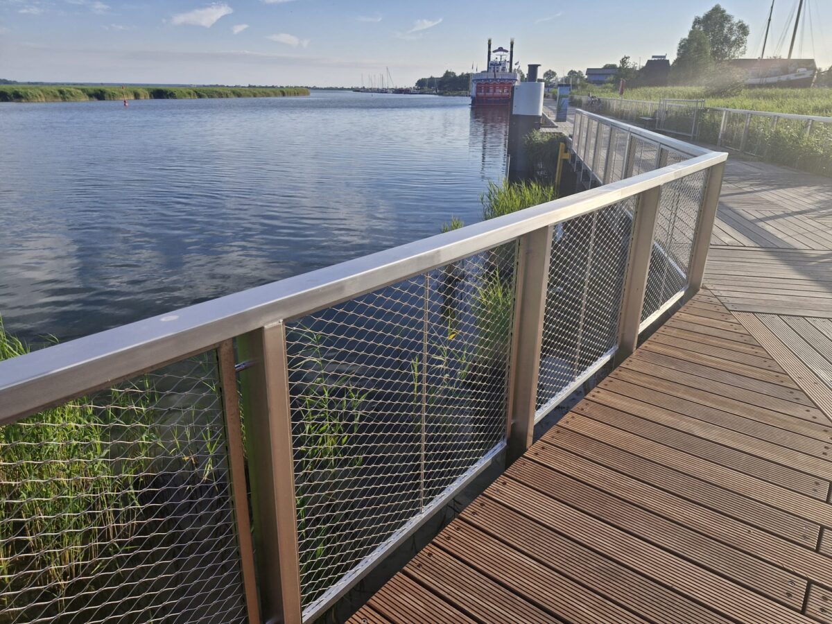 V4A‑Geländer mit Edelstahl‑Seilnetzfüllung an seewasserfester Steganlage im Binnenhafen Zingst.