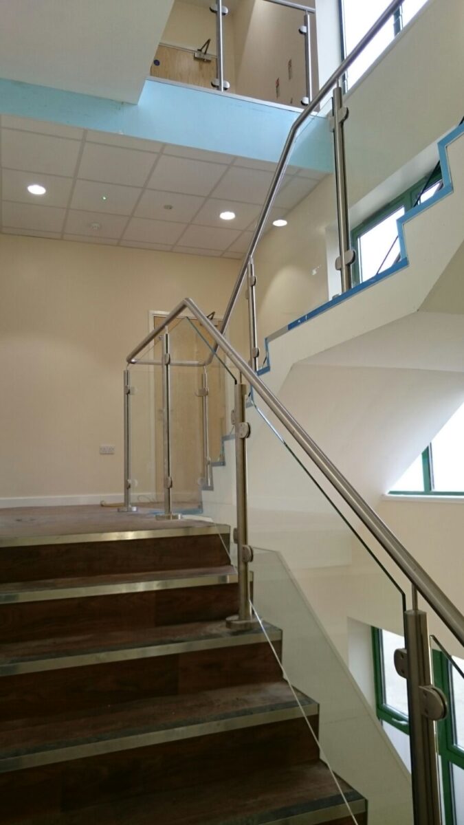 Edelstahl‑Atrium‑ und Treppengeländer mit Glasfüllung an der Ashlawn School in Rugby, gefertigt von Edelstahlverarbeitung Schmitt.