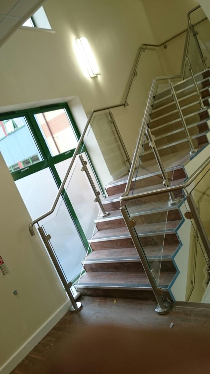 Edelstahl‑Atrium‑ und Treppengeländer mit Glasfüllung an der Ashlawn School in Rugby, gefertigt von Edelstahlverarbeitung Schmitt.