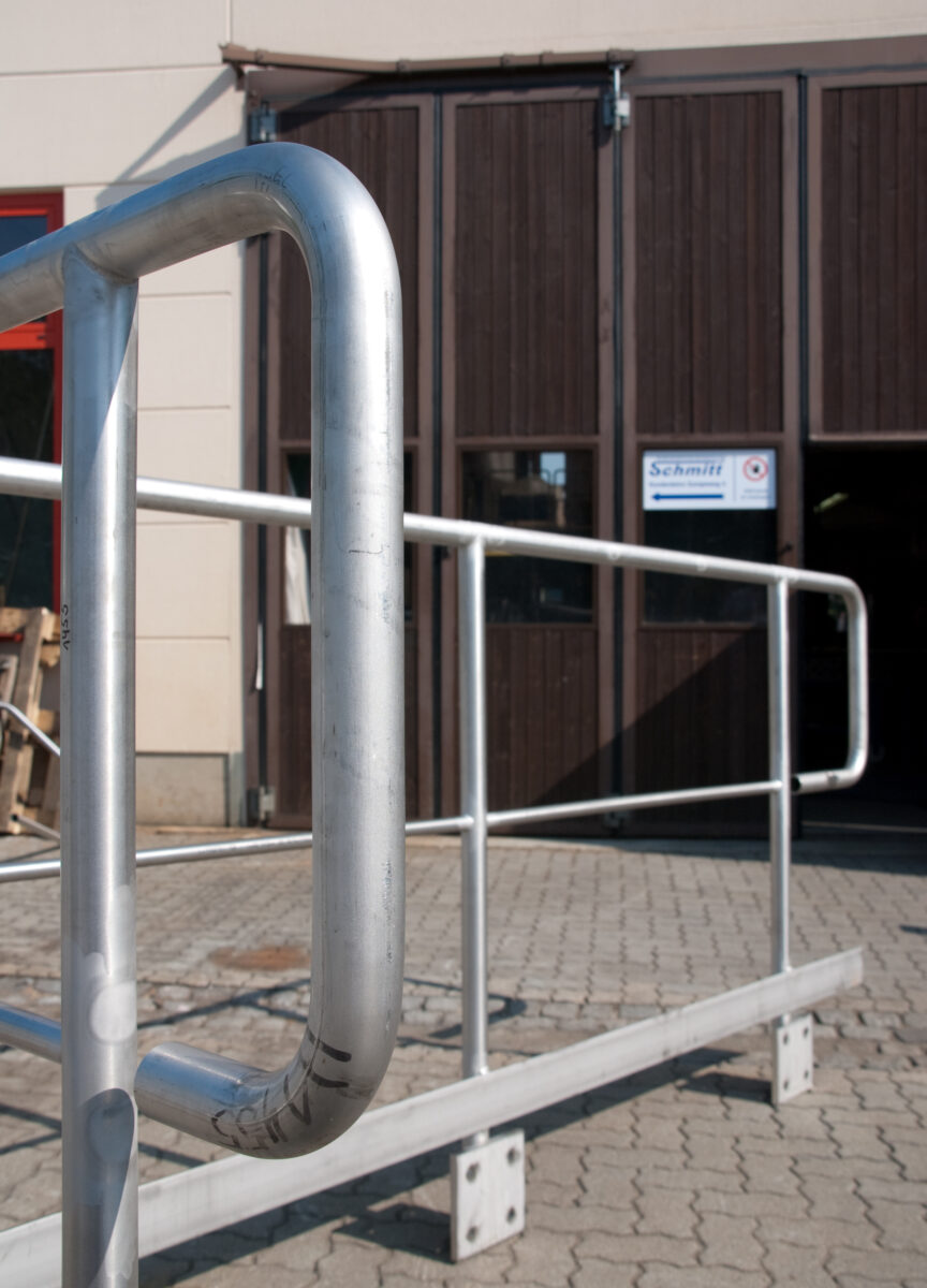 Edelstahl‑Industriegeländer mit Knieleiste, Rohrpfosten und Flachstahl‑Fußleiste – gefertigt von Edelstahlverarbeitung Schmitt aus Sohland/Spree.