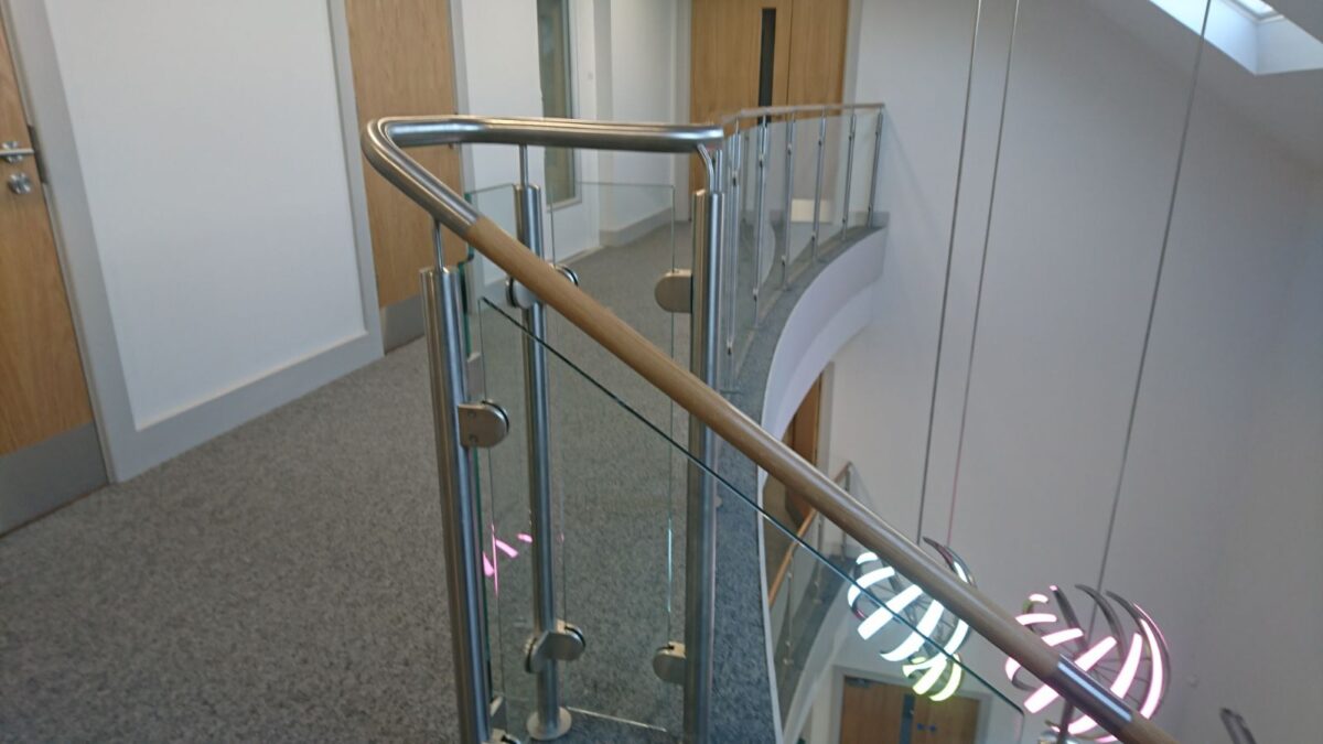 Edelstahl‑Treppengeländer mit Glasfüllung und Holzhandlauf bei Rolawn Limited in York, gefertigt von Edelstahlverarbeitung Schmitt.